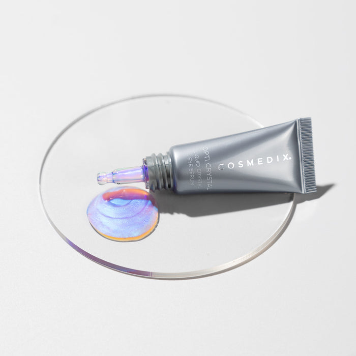 Close up of Rejuvenating Liquid Crystal Bundle with a silver tube and iridescent dropper on a round dish