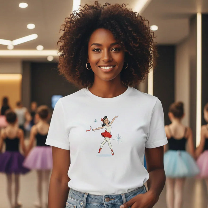 Woman wearing a white t-shirt with a graphic design of a ballerina in a dance studio.