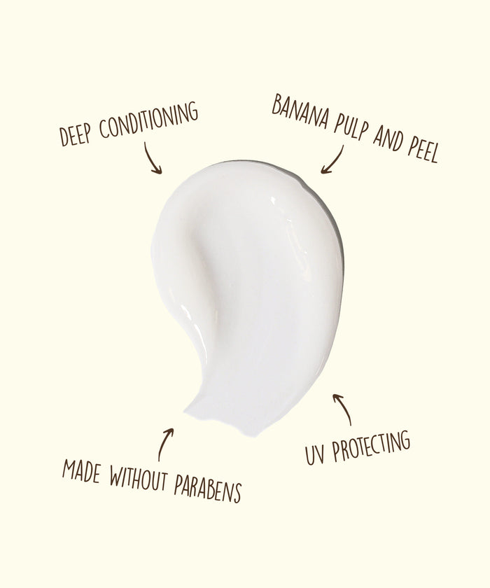 White cream smear with text annotations highlighting deep conditioning, banana pulp and peel, UV protecting, and made without parabens features.
