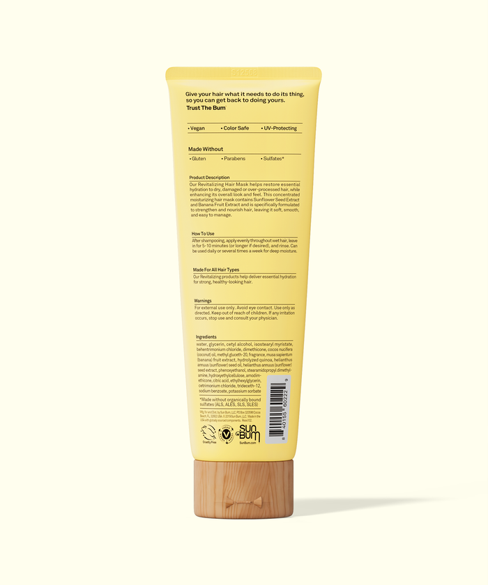 Yellow tube of hair care product with text and a bamboo base on a white background