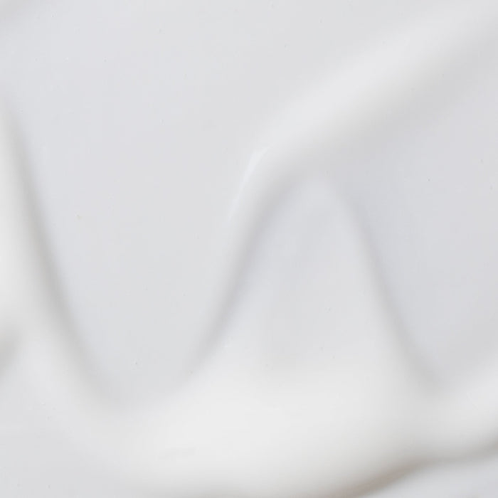 Soft white studio backdrop with subtle folds set for Revive and Renew serum product photo