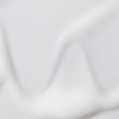 Soft white studio backdrop with subtle folds set for Revive and Renew serum product photo
