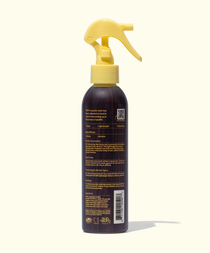 Back view of Sun Bum Sea Spray in a brown bottle with a yellow spray nozzle on a light background