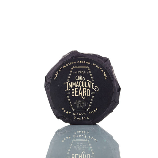 The Immaculate Beard shave soap puck with a smooth, round soap surface in a natural setting, ready for use.