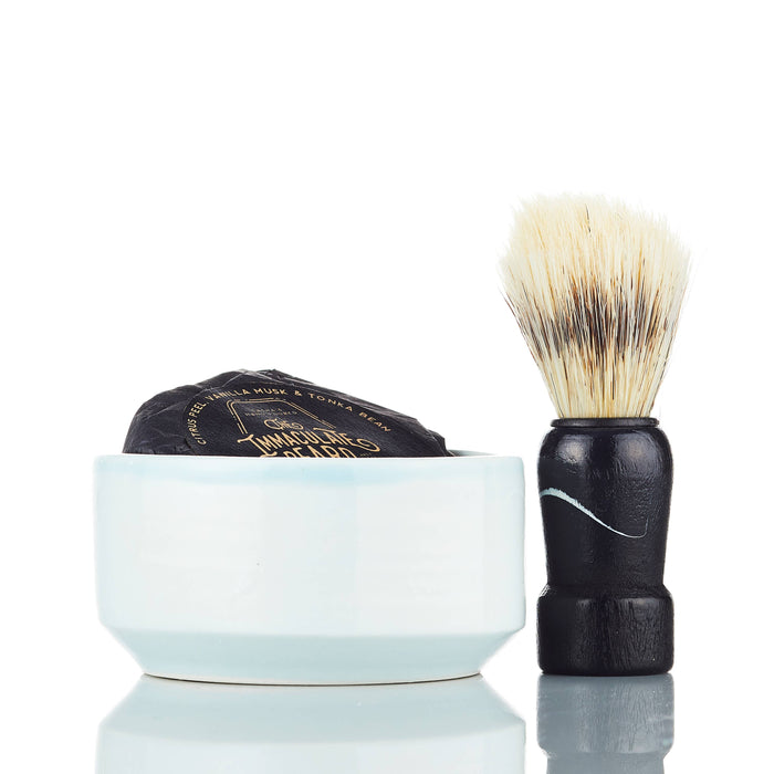 The Immaculate Beard shave soap puck with a smooth, round soap surface in a classic metal container, ready for lathering.