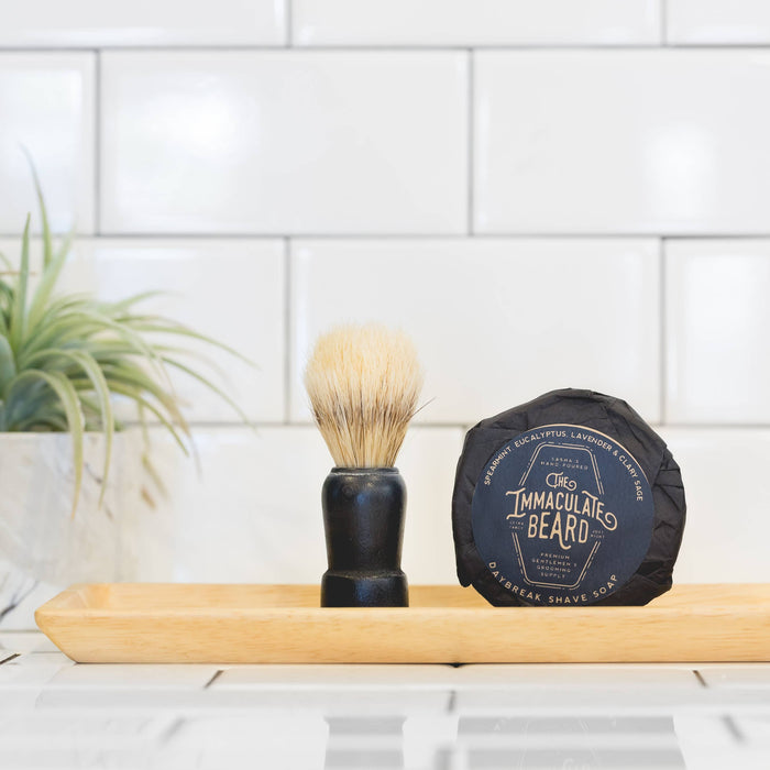 The Immaculate Beard shave soap puck with a white, round soap in a metal tin, ready for a close shave.
