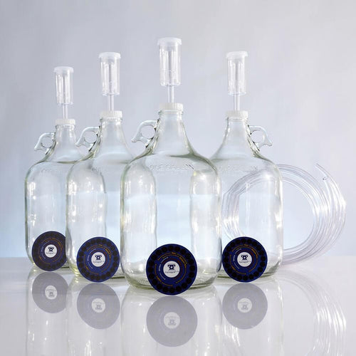 Four one-gallon fermentors, adhesive thermometers, screw caps, lengths of blowoff tubing, and airlocks