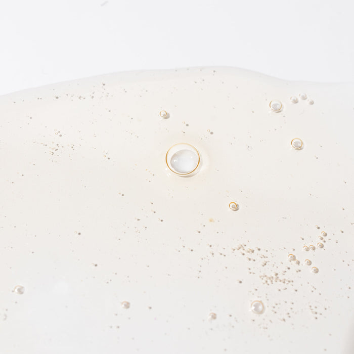 Top portion of Surface Revival toner bottle with silver cap against a pale background