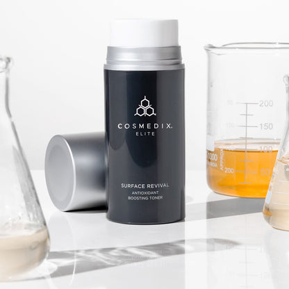 Surface Revival Antioxidant Boosting Toner bottle with a glass lab beaker in the background