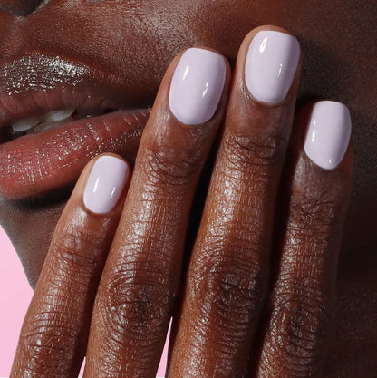 A close-up of light pink polished nails in LONDONTOWN’s Sweet Dreams shade gently touching a face, highlighting smooth nails and detailed skin texture for a soothing, comforting effect.