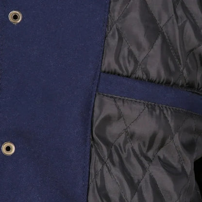 Close-up of a blue and black quilted jacket with button details.